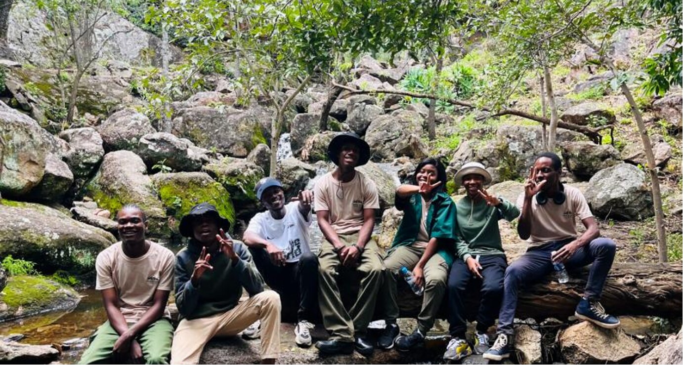Hillside Dams volunteers seated together among rocky woodland